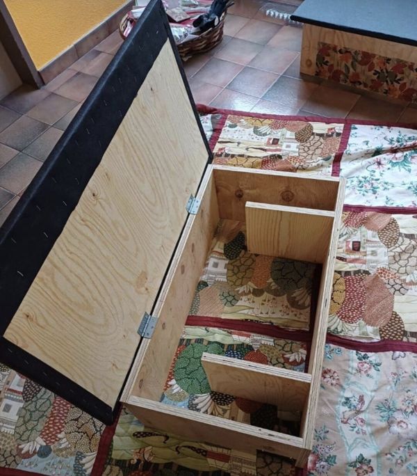 Igel-Futterhaus mit hochgeklapptem Deckel: der bodenlose Holzkasten steht auf einer Decke, im Inneren teilen zwei versetzte Trennw&auml;nde den Vorraum vom Futterbereich